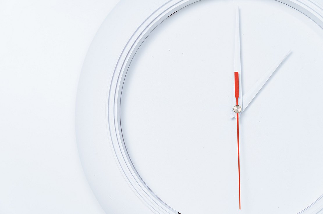 Stilisiertes Bild einer Uhr (Weiße Wanduhr mit weißem Hintergrund, weißen Zeigern, sowie weißer Wand dahinter. Sichtbar ist eine Uhrzeit von 14:00 Uhr mit dem einzigen roten Zeiger auf 30 Sekunden stehend.)